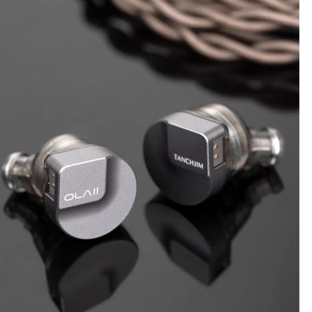 Pair of Tanchjim OLA II hybrid IEM earphones on a neutral background
